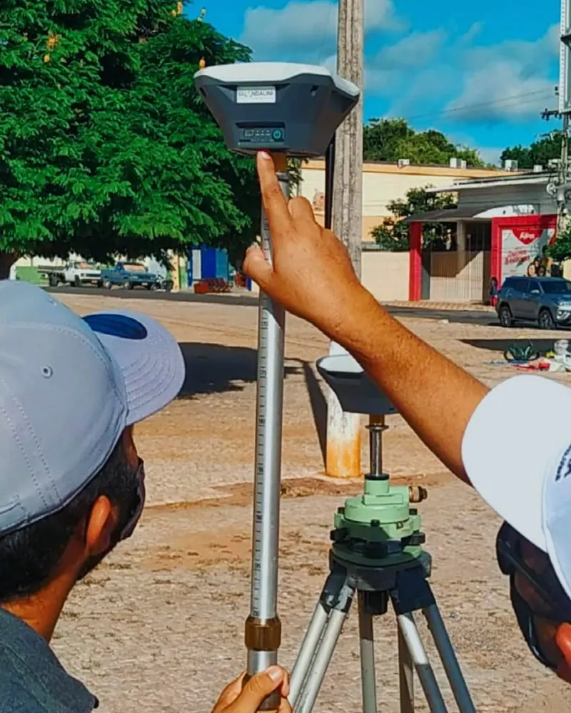 Receptor GNSS montado em bastão sobre tripé, em detalhe