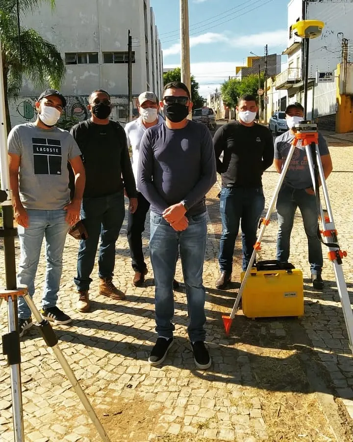 Turma em aula prática com tripés e equipamentos topográficos